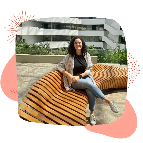 Mulher sentada ao sol com expressão leve e tranquila, representando cuidado médico com estilo de vida